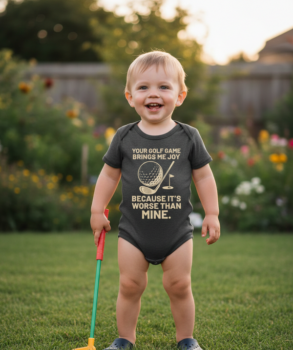 Child wearing a humorous golf-themed onesie in a garden setting. The baby is wearing a Cows Corner baby grow with a funny golf slogan 'Your Golf Game Bring Me Joy, Because It’s Worse Than Mine'.  Cows Corner gifts are perfect for sport-mad fans, these gifts work brilliantly for birthdays, new baby celebrations, Father’s Day, Mother’s Day, Christmas, anniversaries, thank you gifts, end-of-season team awards, graduations, retirements, and just-because moments when you want to raise a smile. 
