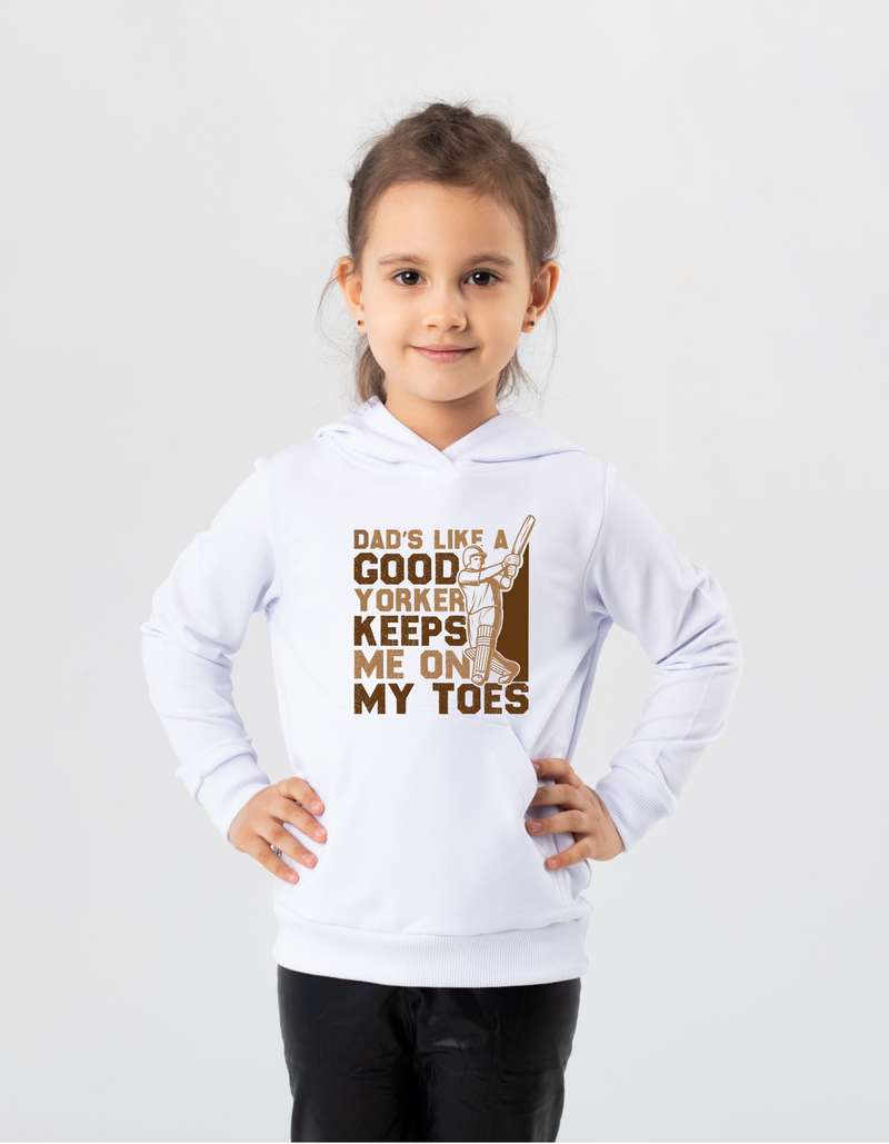 A little girl wearing a white hoodie with Dad’s Like a Good Yorker, Keeps Me on My Toes, on the front!  Funny Cricket Hoodie, Premium Fabric, Multiple Adult Sizes