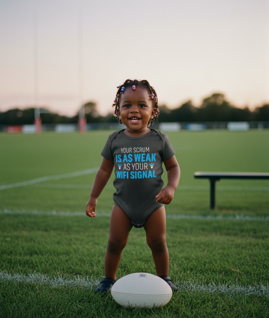 Child wearing a humorous t-shirt on a sports field. The baby is wearing a Cows Corner baby grow with a funny rugby slogan 'Your Scrum Is As Weak as Your WiFi Signal'. Cows Corner gifts are perfect for sport-mad fans, these gifts work brilliantly for birthdays, new baby celebrations, Father’s Day, Mother’s Day, Christmas, anniversaries, thank you gifts, end-of-season team awards, graduations, retirements, and just-because moments when you want to raise a smile. 
