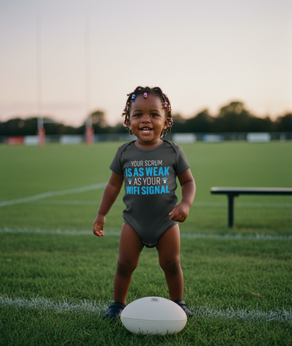 Child wearing a humorous t-shirt on a sports field. The baby is wearing a Cows Corner baby grow with a funny rugby slogan 'Your Scrum Is As Weak as Your WiFi Signal'. Cows Corner gifts are perfect for sport-mad fans, these gifts work brilliantly for birthdays, new baby celebrations, Father’s Day, Mother’s Day, Christmas, anniversaries, thank you gifts, end-of-season team awards, graduations, retirements, and just-because moments when you want to raise a smile. 
