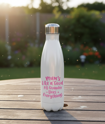 White water bottle with pink text on a wooden surface outdoors. This is a Cows Corner water bottle with a funny cricket slogan 'Mums Like A Good All-rounder, Does Everything'. Cows Corner gifts are perfect for sport-mad fans, these gifts work brilliantly for birthdays, new baby celebrations, Father’s Day, Mother’s Day, Christmas, anniversaries, thank you gifts, end-of-season team awards, graduations, retirements, and just-because moments when you want to raise a smile. 

