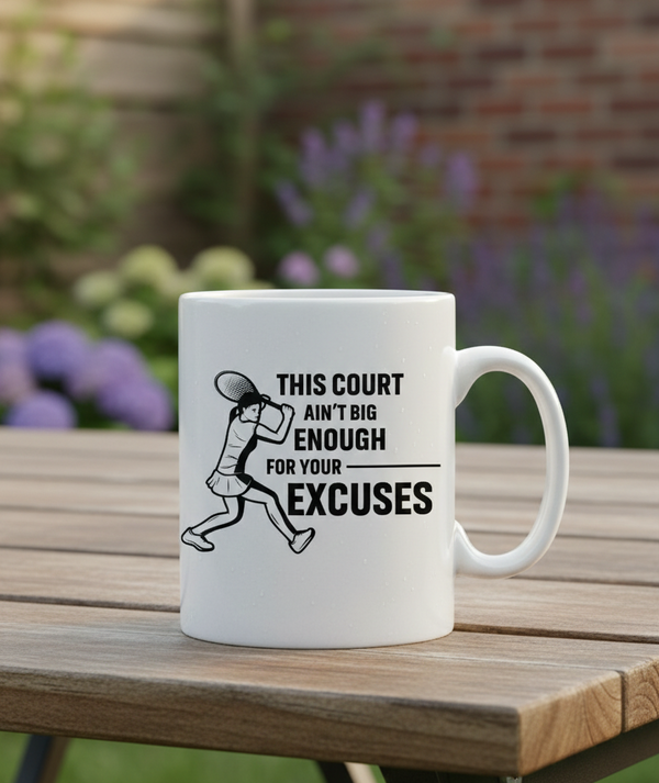 White mug with a graphic and text on a wooden table outdoors. This is a Cows Corner mug with a funny tennis slogan 'This Court Ain't Big Enough For Your Excuses'. Cows Corner gifts are perfect for sport-mad fans, these gifts work brilliantly for birthdays, new baby celebrations, Father’s Day, Mother’s Day, Christmas, anniversaries, thank you gifts, end-of-season team awards, graduations, retirements, and just-because moments when you want to raise a smile. 
