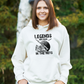 A lady wearing a white hoodie with Legends Are Made in The Nets on the front. A Funny Cricket Hoodie, Premium Fabric, Multiple Adult Sizes