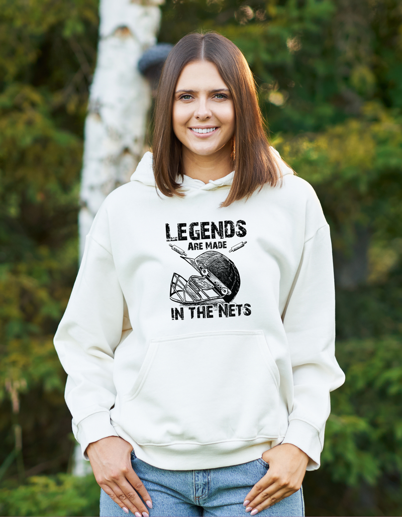 A lady wearing a white hoodie with Legends Are Made in The Nets on the front. A Funny Cricket Hoodie, Premium Fabric, Multiple Adult Sizes