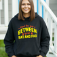A lady wearing a black hoodie with Mind the Gap Between Your Bat and Pad on the front. A Funny Cricket Hoodie, Premium Fabric, Multiple Adult Sizes