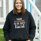 A lady wearing a black hoodie with Your Sledging Is as Soft as Your Bowling on the front.  A Funny Cricket Hoodie, Premium Fabric, Multiple Adult Sizes