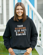 A lady wearing a black hoodie with Your Sledging Is as Soft as Your Bowling on the front.  A Funny Cricket Hoodie, Premium Fabric, Multiple Adult Sizes