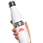 White Cows Corner water bottle with text held by a hand on a white background