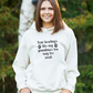 A lady wearing a white hoodie with Your Bowling’s Like My Grandma’s Tea, Way Too Weak, on the front - Funny Cricket Hoodie, Premium Fabric, Multiple Adult Sizes